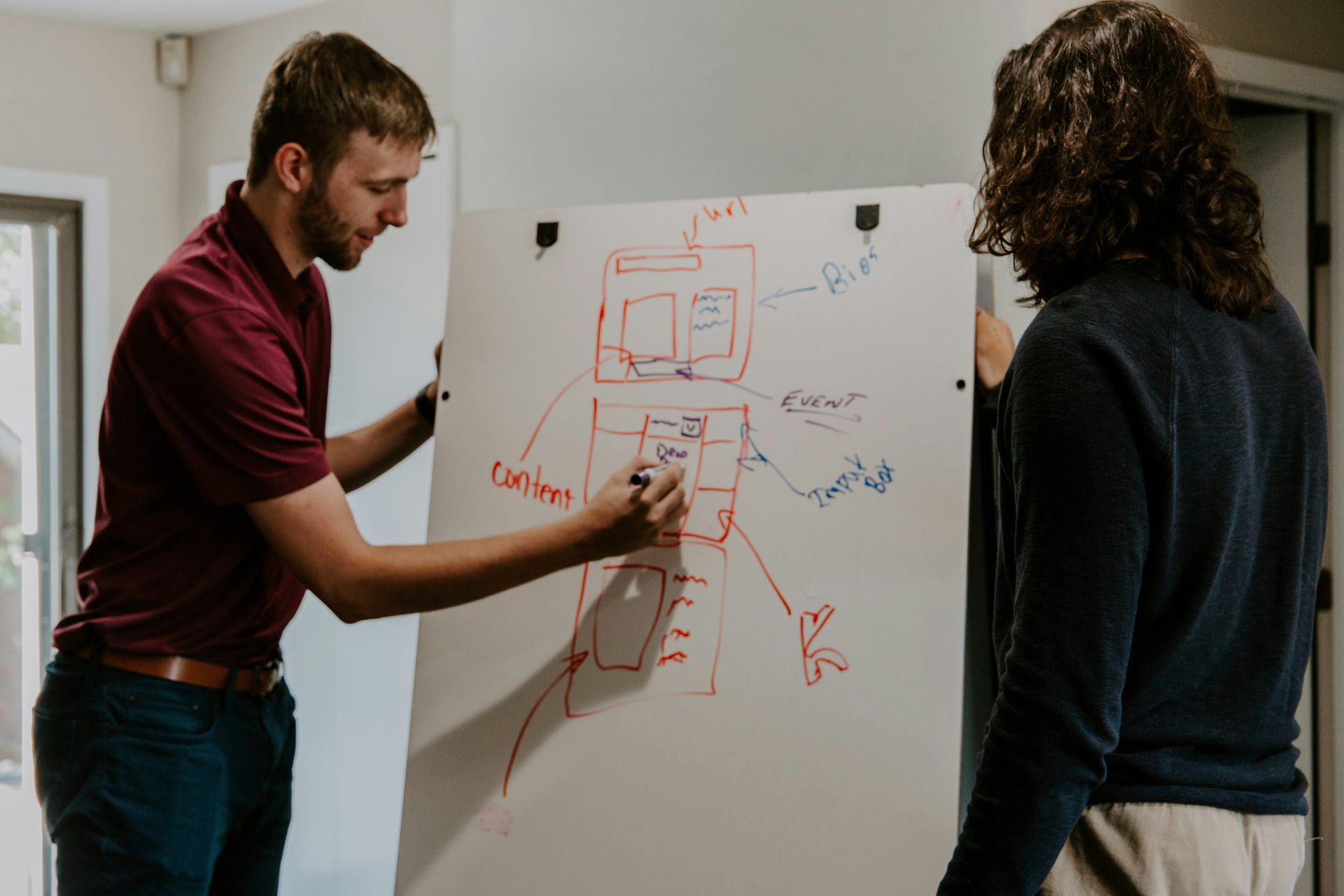 Mann zeichnet auf ein Whiteboard